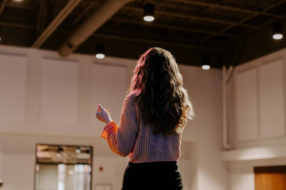 Los estilos de liderazgo más destacados en el mundo tecnológico 1 Mujer dando una charla frente a un público como ejemplo de los distintos estilos de liderazgo en acción