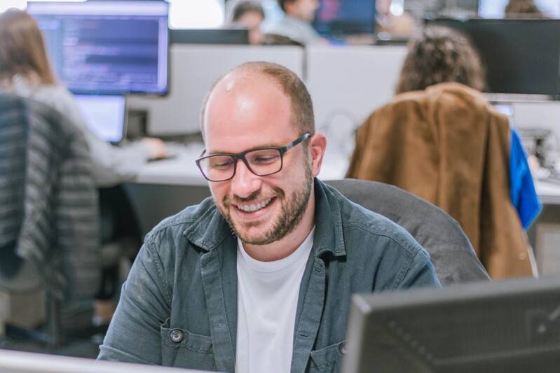 Arquitecto de la nube (cloud architect): rol, herramientas y habilidades + 9 pasos para convertirte en uno 1 Arquitecto en la nube que sonríe