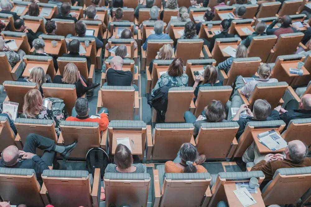 federated learning conference with laptops and participants in a large auditorium