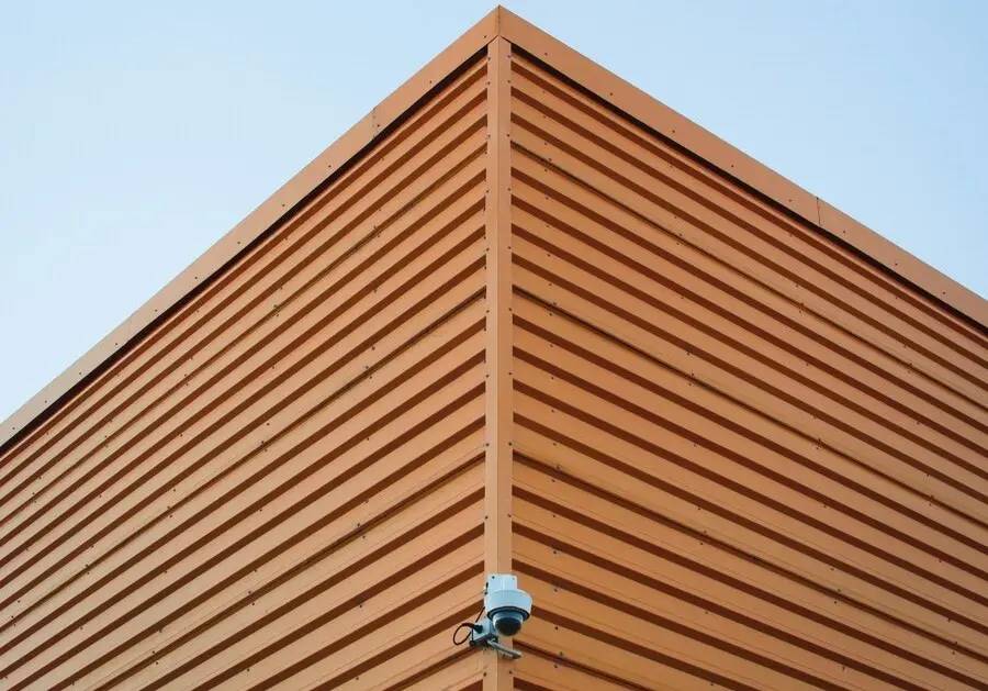 industrial computer vision camera mounted on the corner of a wooden building facade