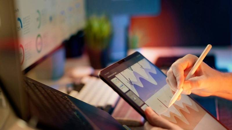 Revenue management en turismo: integración de IA y BI mediante middleware modular 4 Profesional revisando gráficos en una tablet que ilustran la conexión entre GDS y el middleware SofIA de OpenSistemas.