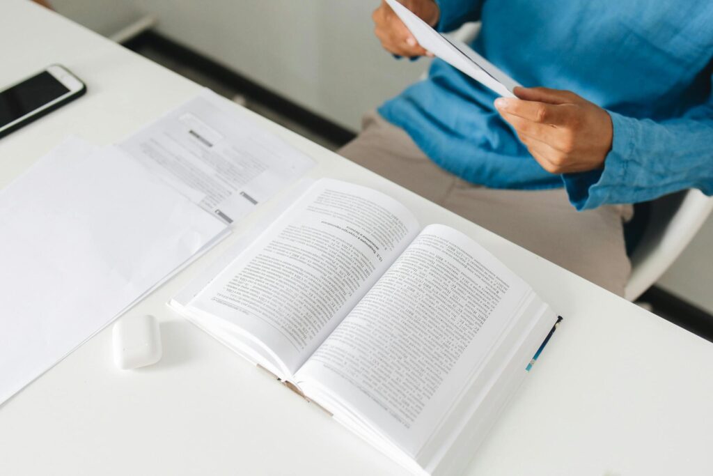 Persona leyendo un libro en un escritorio, reflejando el enfoque del aprendizaje adaptativo en el progreso individual