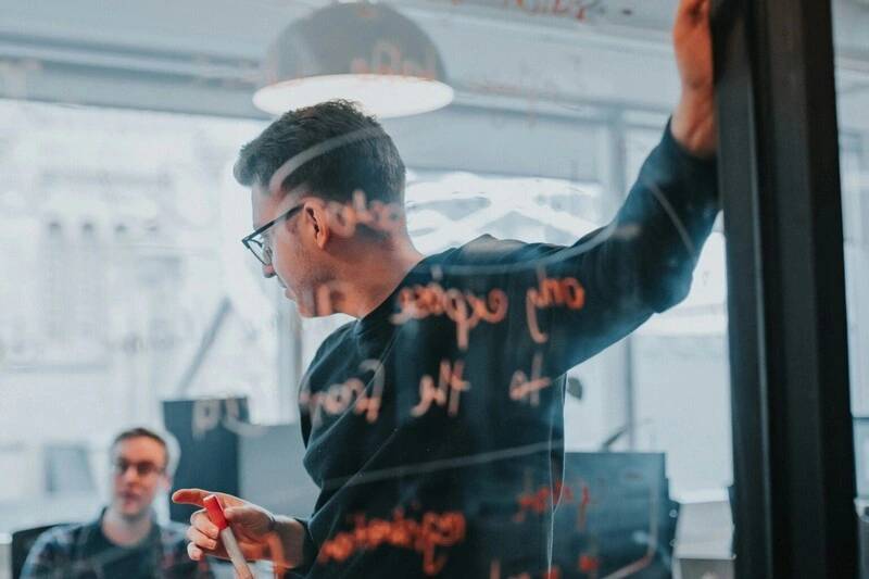 Persona explicando en un tablero LXP-con-IA-orquestacion-de-modelos