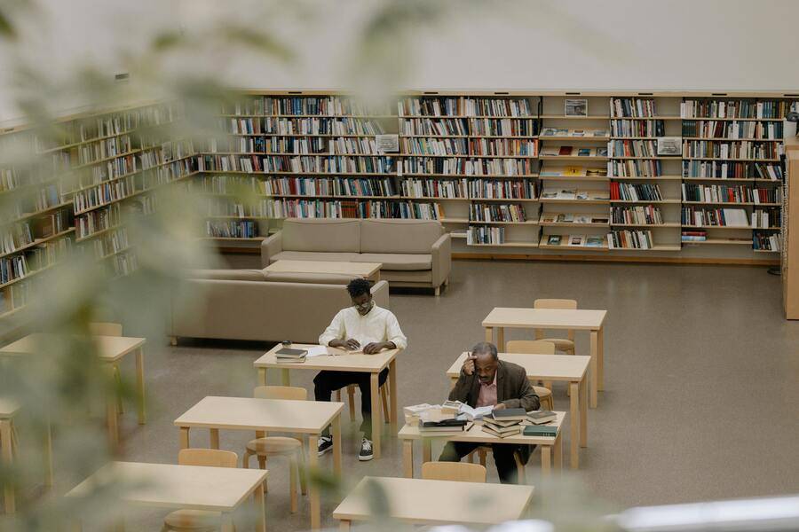 Cómo la tecnología educativa con IA optimiza los procesos y la experiencia de usuario 1 Biblioteca llena de estudiantes usando computadoras, muestra del entorno colaborativo que promueve la tecnología educativa.