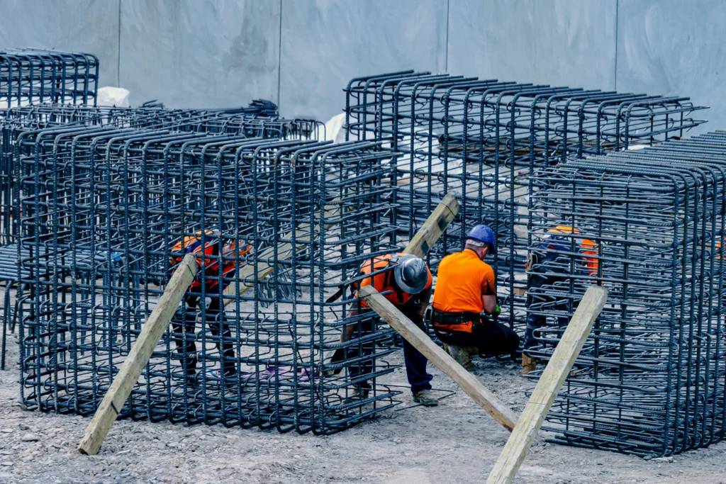 obreros ensamblando la estructura firme de un edificio, representa el futuro inteligente y automatizado del gobierno de datos