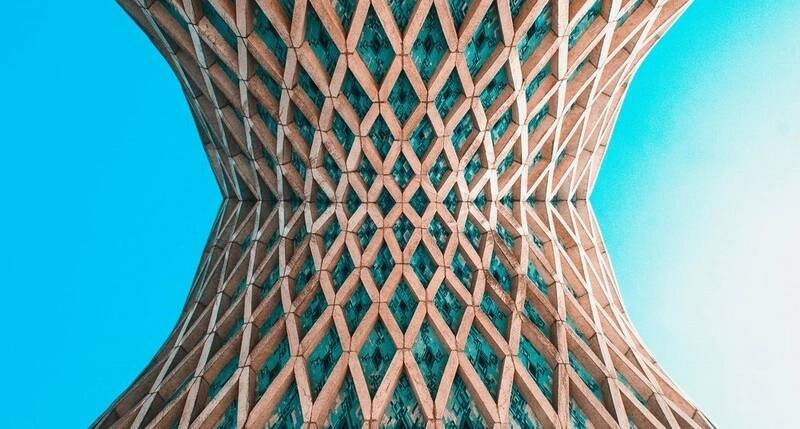 Estructura arquitectónica con curva y diseño geométrico entrelazado vista desde abajo