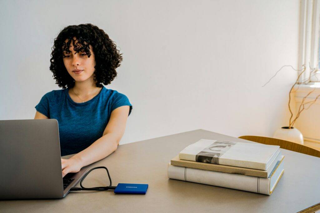 Mujer joven estudiando un curso online desde su casa