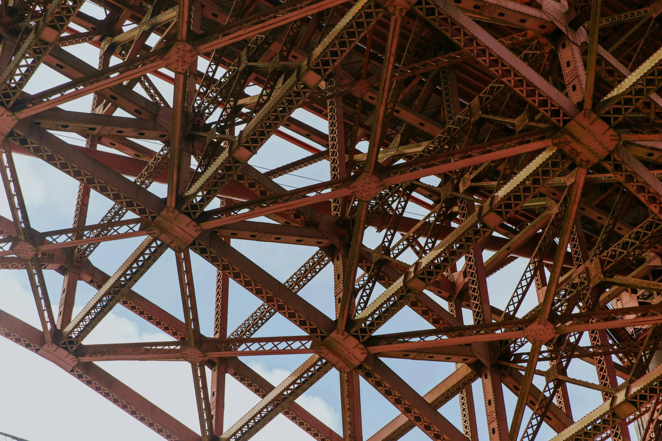 Puente metálico con cables entrelazados que simbolizan la complejidad del debugging en arquitecturas modernas