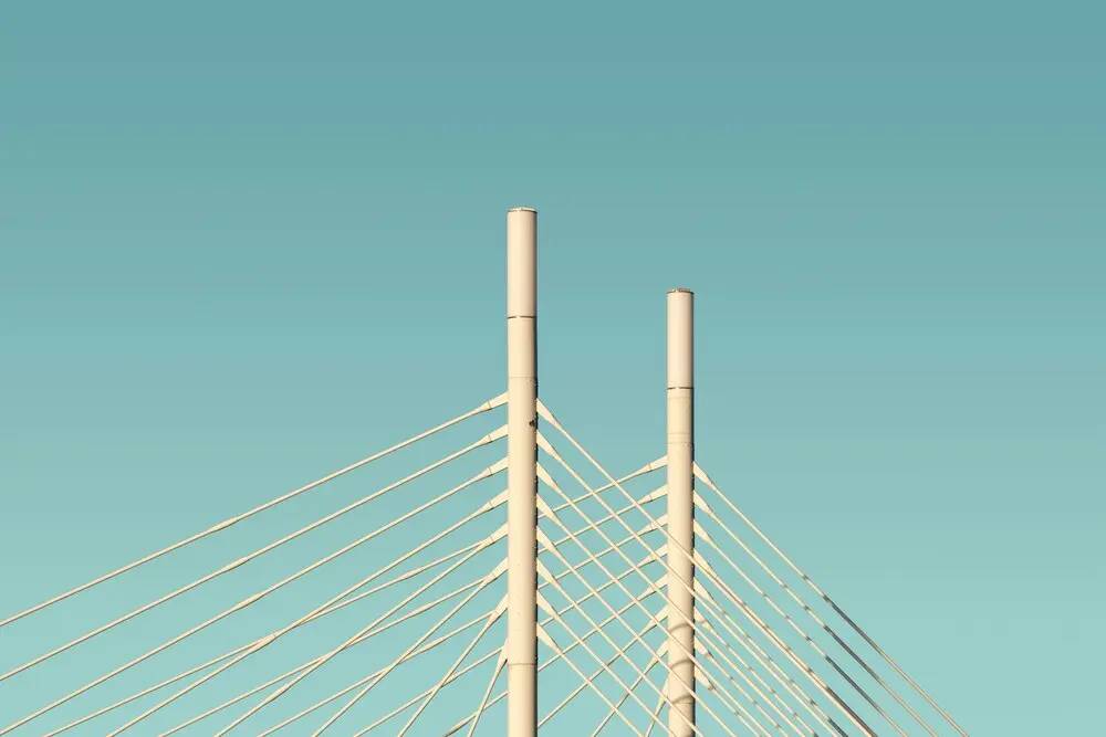 Puente metálico con cables entrelazados que simbolizan la complejidad del debugging en arquitecturas modernas