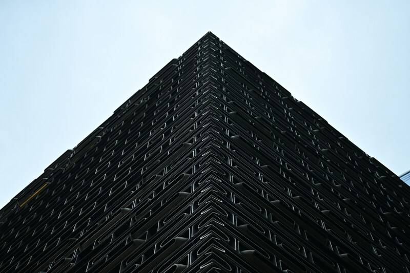 Edificio oscuro en forma de bloque usado como metáfora de la caja negra que supone usar IA para programar Python sin transparencia ni control