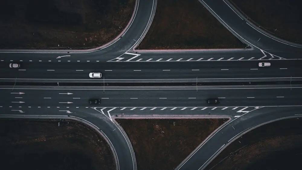 Cruce de carreteras visto desde arriba como metáfora de decisiones operativas guiadas por algoritmos predictivos e inferencia contextual.