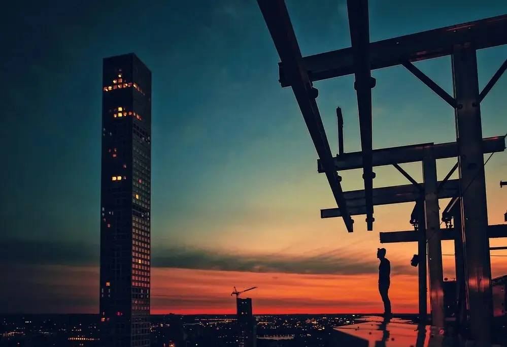 Innovación empresarial: de la adopción tecnológica a la dirección estratégica 3 Estructura metálica en altura frente a una ciudad al atardecer que simboliza la madurez de la innovación empresarial