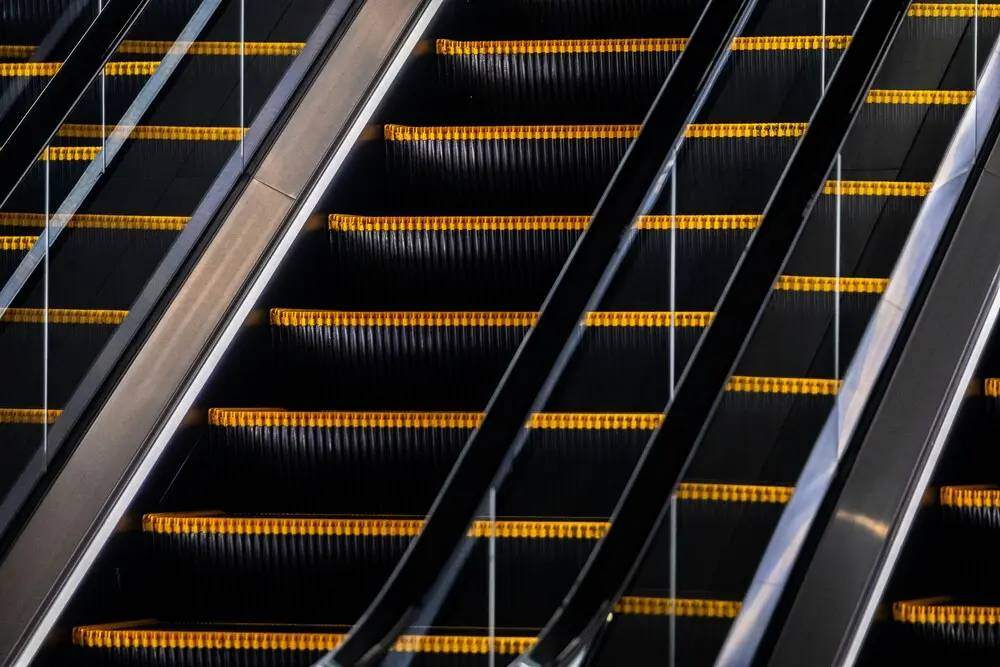 La evolución del smart retail en la experiencia de compra inteligente 2 Escaleras eléctricas en funcionamiento que reflejan dinamismo y mejora continua en el smart retail