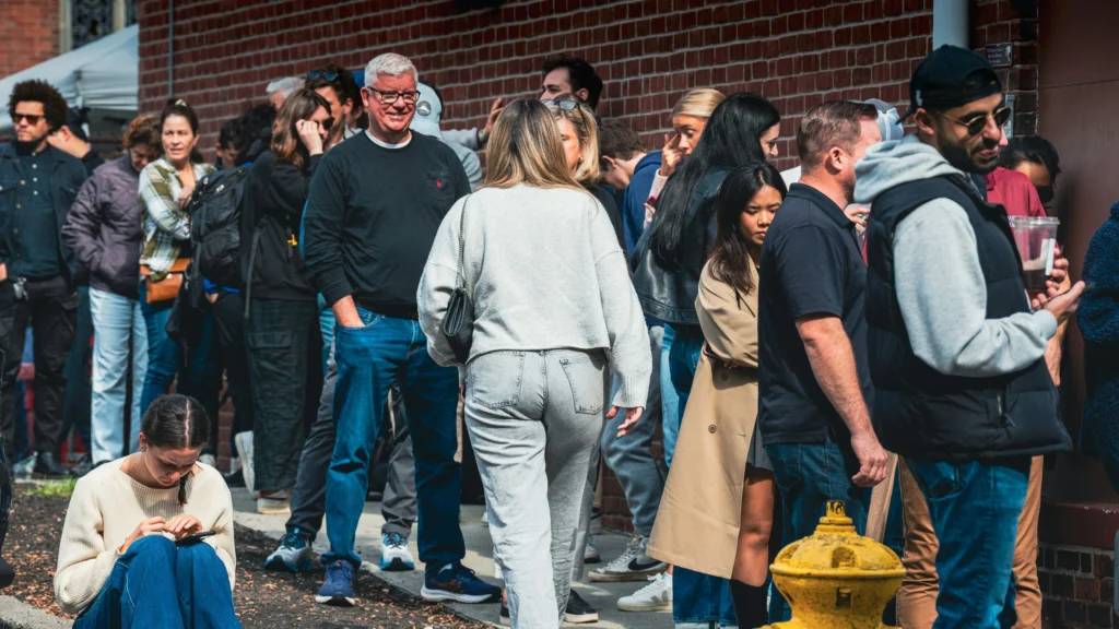 grupo de ciudadanos esperando a las puertas de un edificio público de una administración local haciendo cola para realizar un trámite administrativo